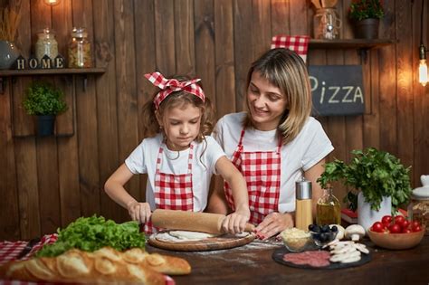 Premium Photo Mother Teaching Daughter Cooking Pizza And Smiling