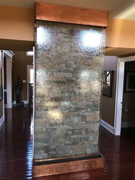 Residential Stone Wall Behind Glass Water Wall For An Indoor Waterfall