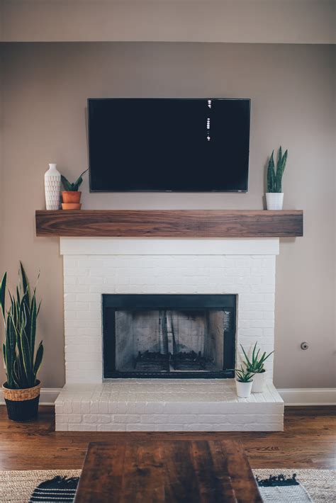 The wooden mantel stretches across the whole length of the brick wall, giving you lots of room for your decor. Modern White Brick Fireplace & Walnut Mantel DIY - The ...