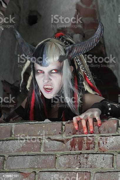 Scary Hungry Female Demon Crawling Over Old Dirty Brick Wall Stock