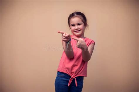 A Portrait Of Happy Kid Girl Pointing Finger At Something Children And