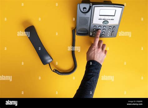 Top View Of A Male Finger Dialing A Telephone Number Using Black
