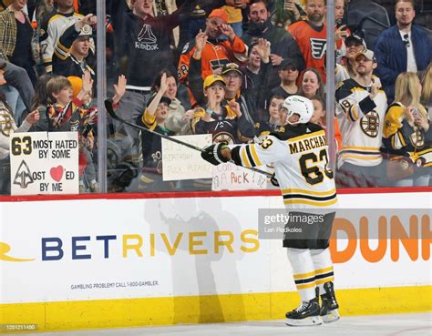Brad Marchand Of The Boston Bruins Flips A Puck Towards Several Rows