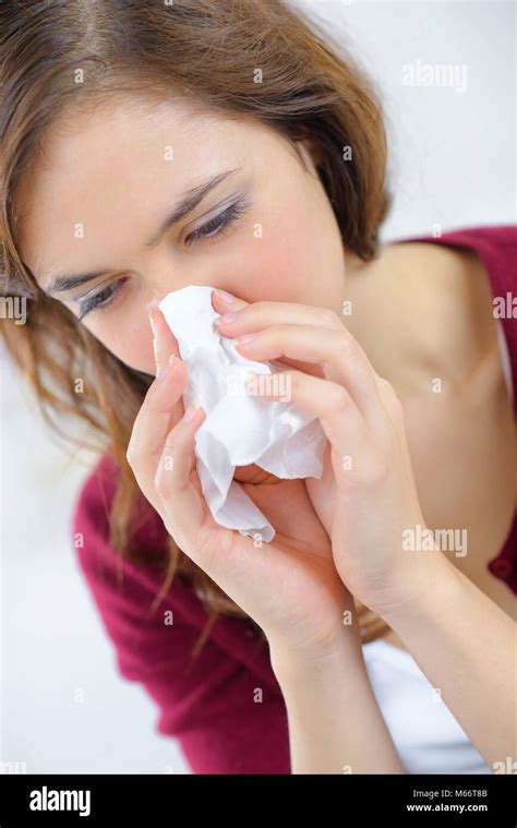 Burnette Woman Blowing Nose Into Tissue Stock Photo Alamy