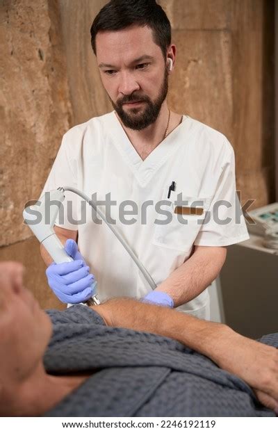 Extremely Focused Male Doctor Treating Patient Stock Photo 2246192119