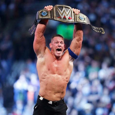 A Man Holding Up A Wrestling Belt In The Air