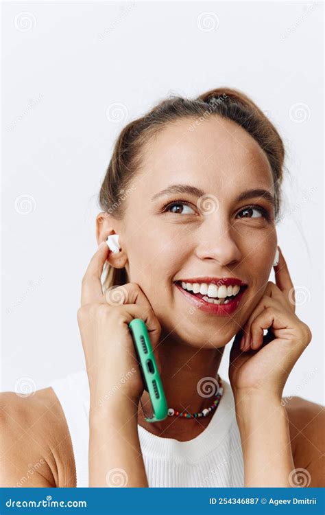 A Woman Listening To Music And Audio On Wireless Headphones And Smiling