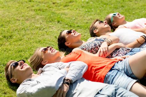 Group Of Smiling Friends Lying On Grass Outdoors Stock Image Image Of