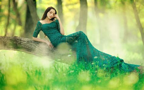 Обои на рабочий стол Девушка в зеленом платье лежит на стволе дерева в весеннем лесу обои для