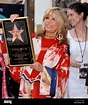 Singer and actress Nancy Sinatra holds a replica plaque as her daughter ...