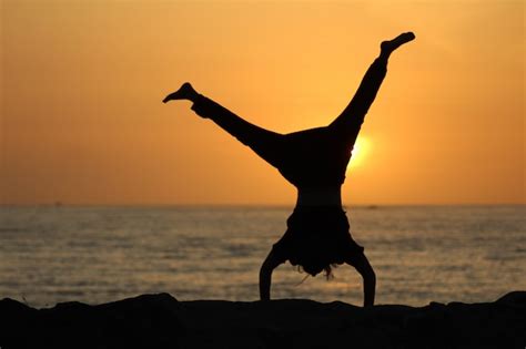 Silhouette Of A Female Doing A Cartwheel With A Blurred Sea And A Clear