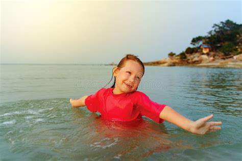 Счастливый ребенок играя в море Стоковое Фото изображение