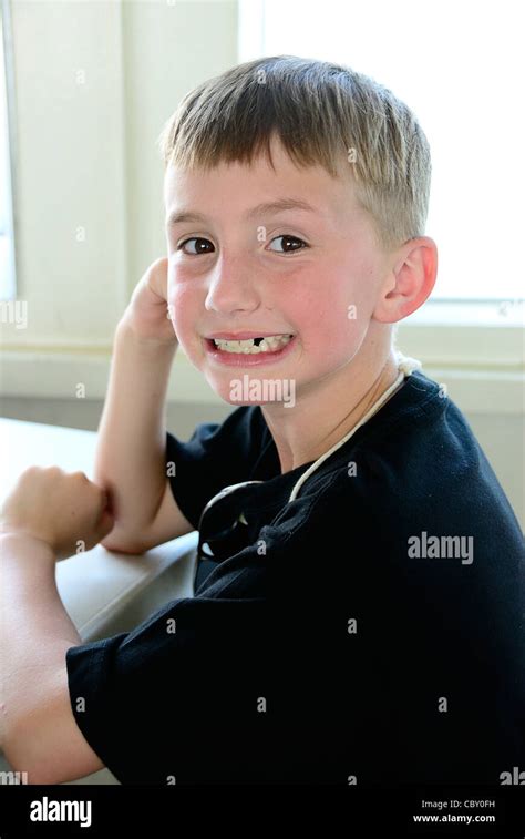 Young Boy Who Is Missing A Tooth Smiling At The Camera Stock Photo