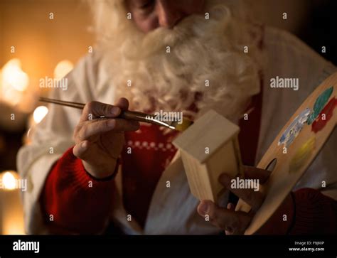 Santa Claus At Home Making Toys And Painting Stock Photo Alamy