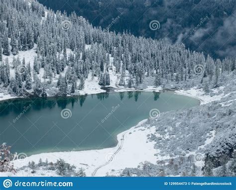 Turquoise Colored Alpine Lake In Winter In Between Mountains Stock