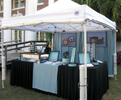A White Tent With Black Table Cloths And Pictures On It