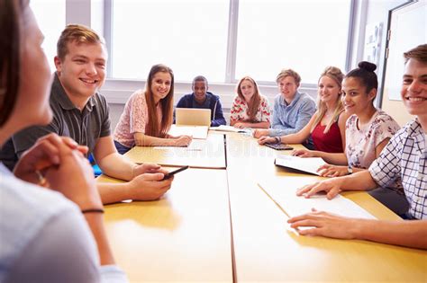 Group Of College Students Sitting At Table Having