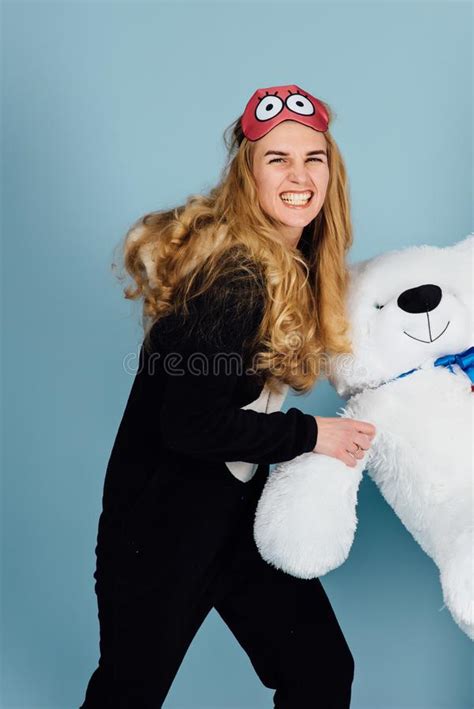 A Beautiful Young Woman Wearing Pajamas Hugging Her Stuffed Teddy Bear
