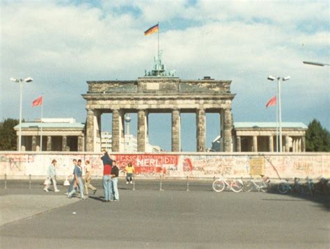 A german women hangs clothing out to dry on a line strung between a tree and the berlin wall. Brandenburg Gate behind Berlin Wall - 1988 | See a related ...