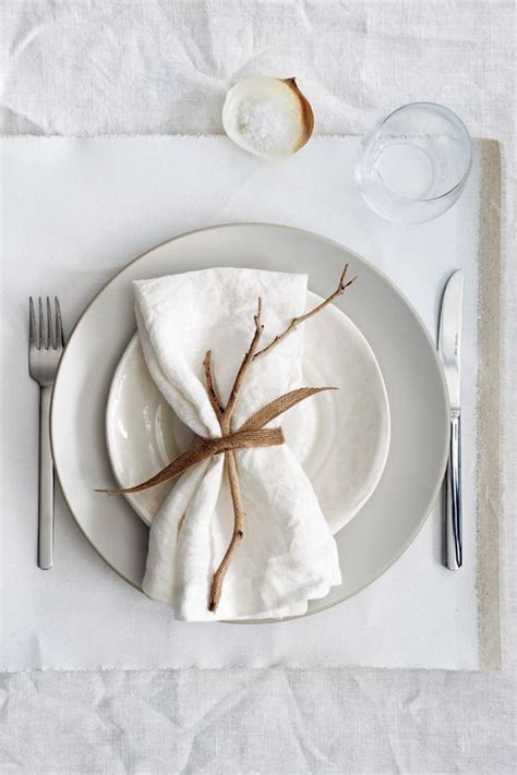 A White Plate Topped With Two Napkins Next To A Fork And Knife On Top