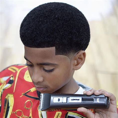 The black toddler boy in the photo has a big afro curly spongy haircut with a middle part. awesome 25 Cool Ideas for Black Boy Haircuts - For Cute ...