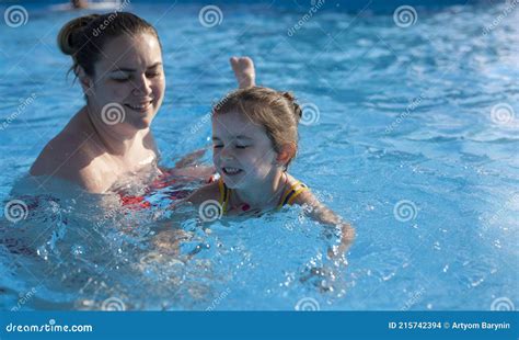Mom Teaches Her Little Daughter To Swim The Coach Teaches A Girl To Swim In The Pool Rest In