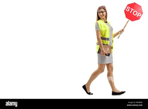 Full Length Shot Of A Young Woman With Safety Vest And Stop Sign