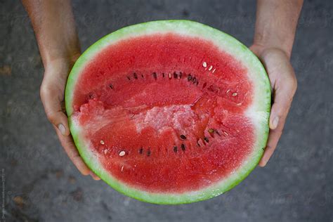 Watermelon Cut In Half In Hands By Stocksy Contributor Demetr White
