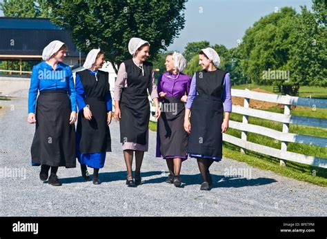 Young Amish Women Friends Walking Down Country Lane Road In Lancaster