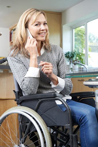 Disabled Woman In Wheelchair Making Call On Mobile Phone Stock Photo