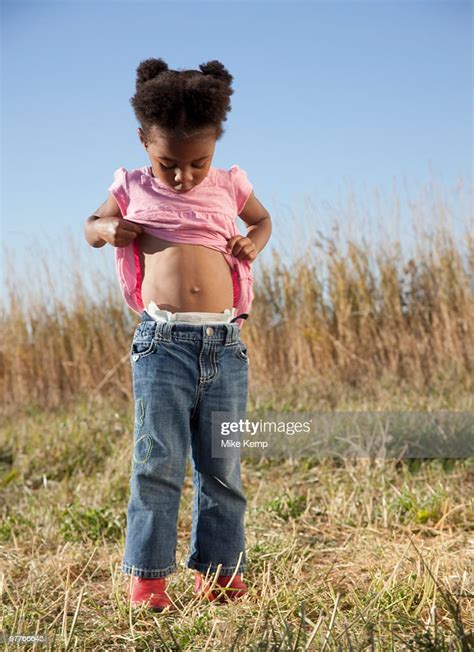 Young Girl Looking At Her Belly Button Photo Getty Images