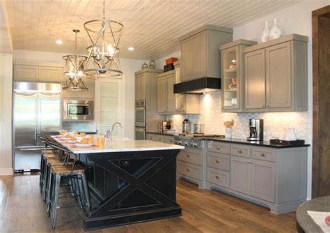 For many years now all shades of cream and magnolia have been shunned for brilliant white and hues of grey. Kitchen with painted black island and gray wall cabinets