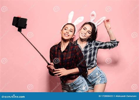 Two Young Caucasian Woman Wearing Cute Easter Rabbit Ears Making Selfie