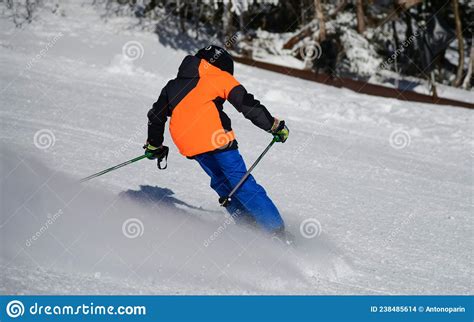 Action Photo Of Skier In Bright Outfit Going Down The Slope Leaving