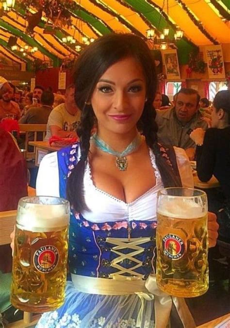 A Woman Is Holding Two Mugs Of Beer