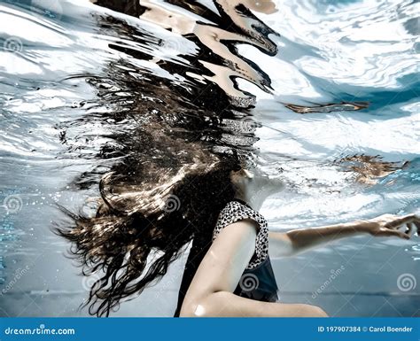 a girl`s long hair flowing underwater and reflections on the undersurface of the water stock