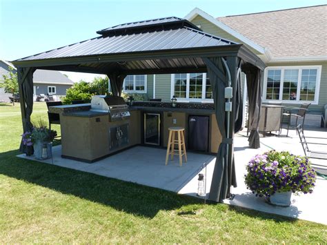 An Outdoor Kitchen And Grill Area In A Backyard