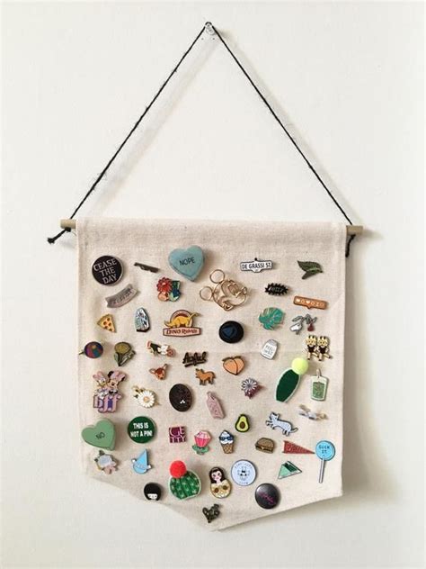A White Wall Hanging With Various Pins And Magnets On Its Back Side