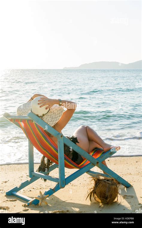 Beautiful Woman Sunbathing In A Bikini On A Beach At Tropical Travel Resort Enjoying Summer