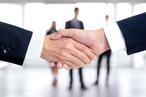 Handshake of businessmen on blur businesspeople background ...