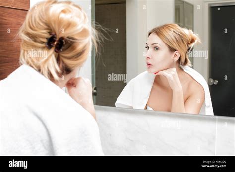 Woman Looks At Herself In The Bathroom Mirror Stock Photo Alamy