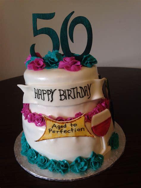 A 50th Birthday Cake Decorated With Flowers And Ribbons