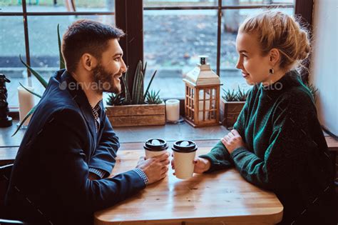 Romantic Couple In The Cafe Is Drinking Coffee And Talking Stock Photo