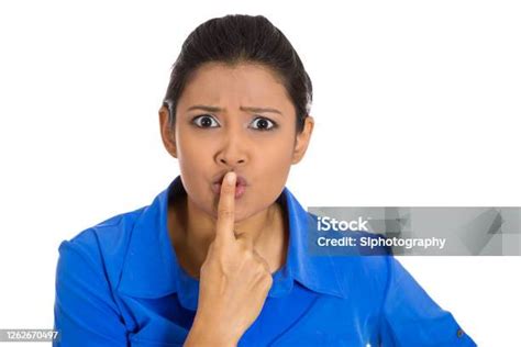 Serious Woman Placing Finger On Lips Asking For Silence Stock Photo
