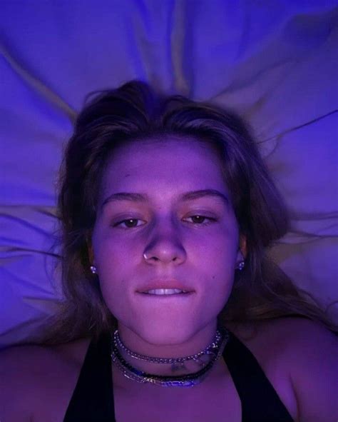 A Woman Laying In Bed With Her Eyes Closed And Wearing A Choker Around Her Neck