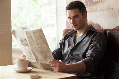 Man Reading Newspaper And Drinking Coffee In Cafe Stock Photo Dissolve