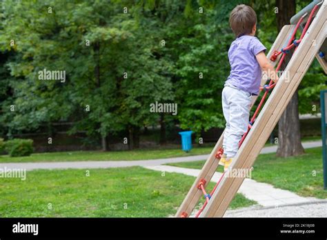 A Boy Not Recognizable Climbs A Rope Ladder In A Childrens Park