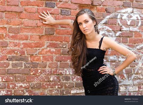 Pretty Girl Standing Alone Near Grunge Wall Stock Photo