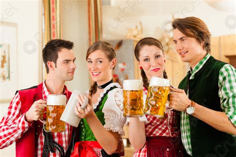 Young People In Traditional Bavarian Tracht In Restaurant Or Pub