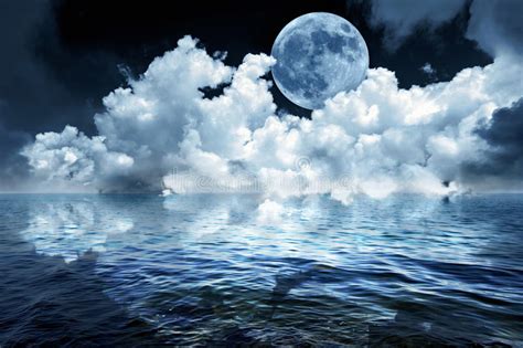 Big Full Moon In Night Sky Over The Ocean Reflecting In Calm Water